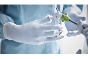 Hand mit Biogel Handschuh, die eine monopolare Schere hält