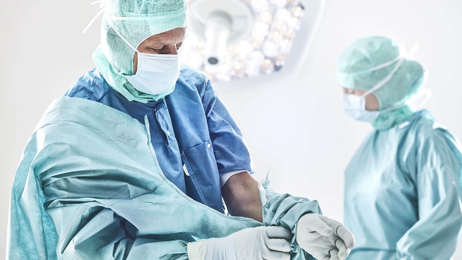 Chirurgien enfilant une casaque avant une intervention chirurgicale